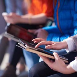 Students Using Tablets And Sitting Together